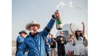 Jeff Bezos celebrates his first spaceflight with a bottle of champagne.