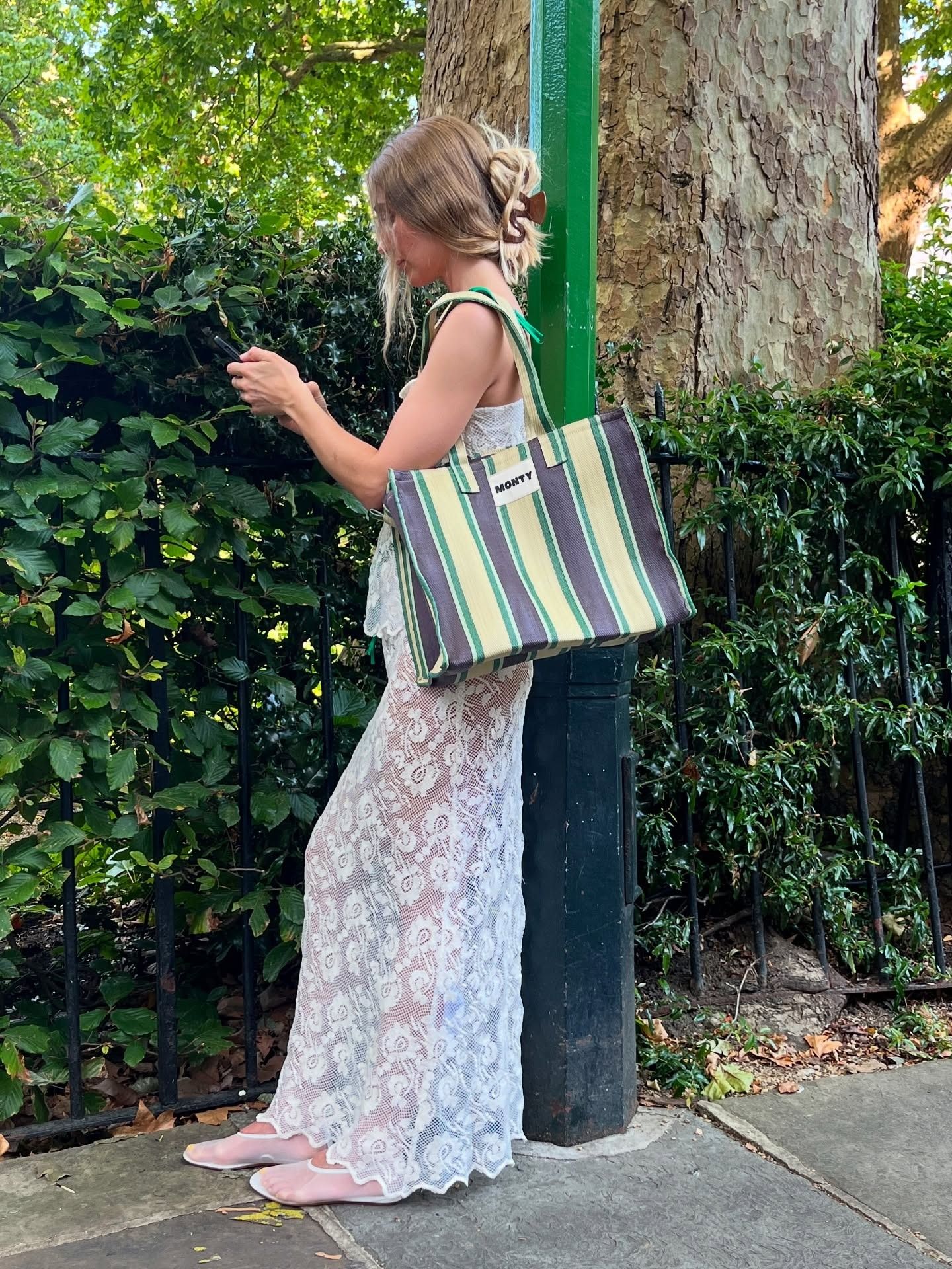 Woman holding a Monty striped tote bag.