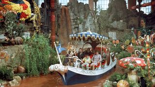 A still from the movie Willy Wonka and the Chocolate Factory in which the main cast take a ride on a boat down a chocolate river.