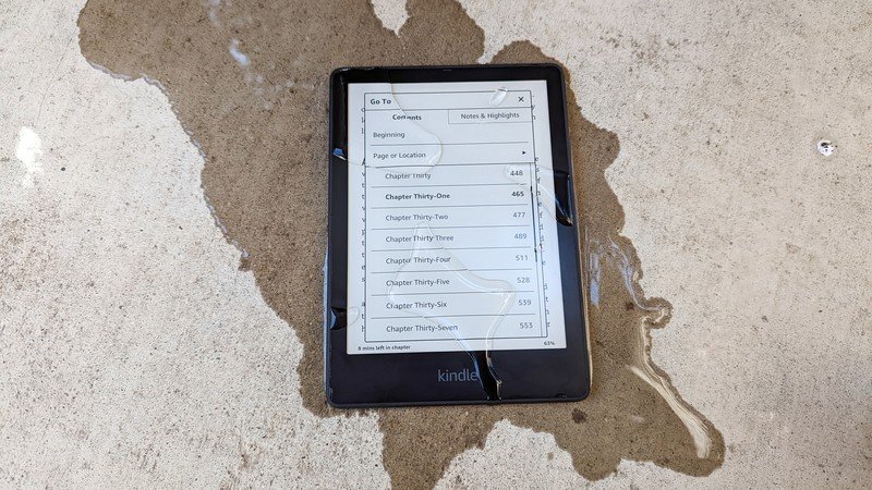 Laying Amazon Kindle Paperwhite Signature Edition on the floor with water sprayed over it