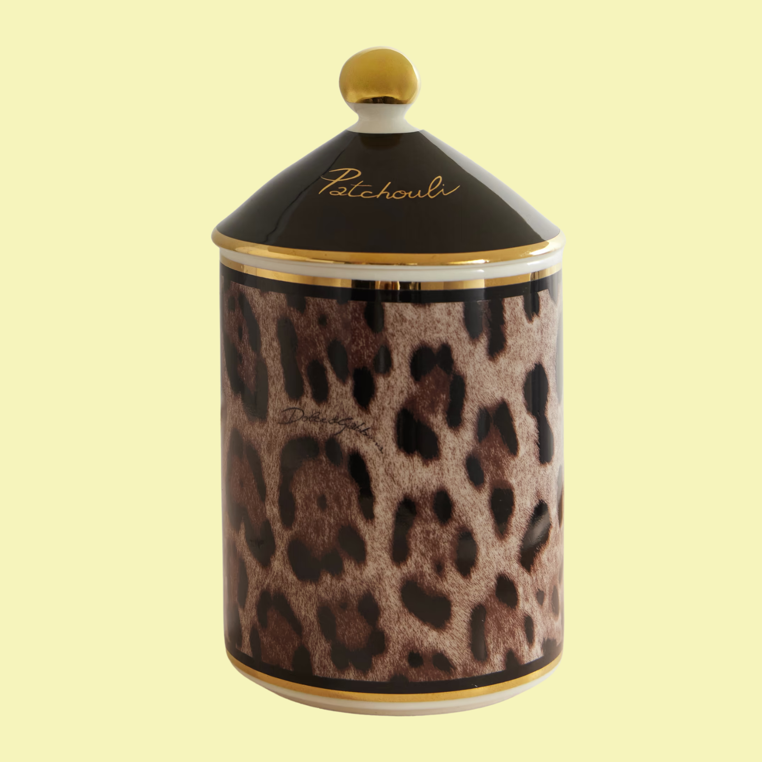 A candle with a leopard print vessel and a black lid