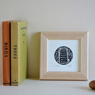 frame with linocut print and books
