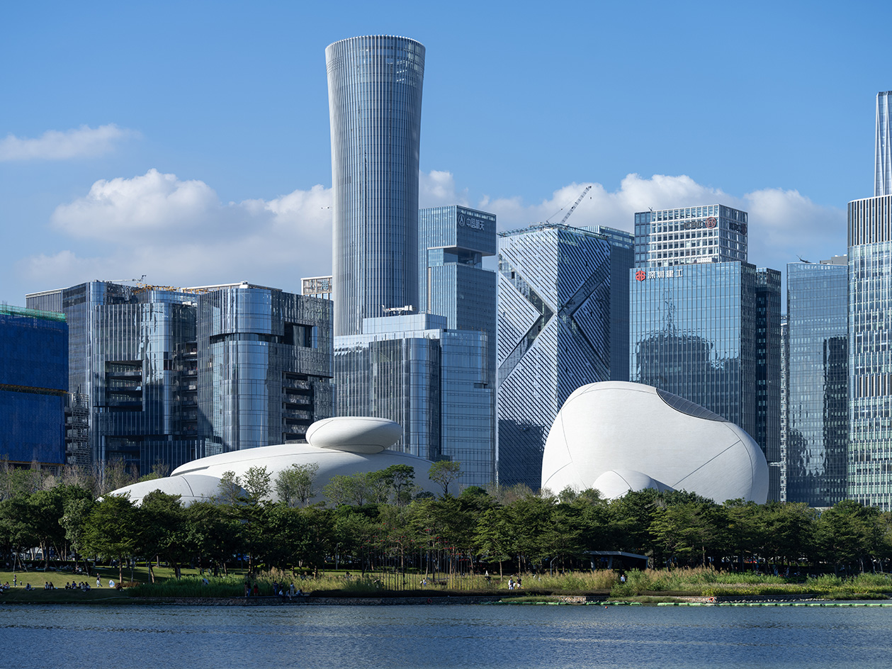 view of MAD Shenzhen Bay Culture Square, all white volumes and curves in a green park
