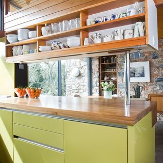 kitchen area with yellow cabinet and wooden crockery storage
