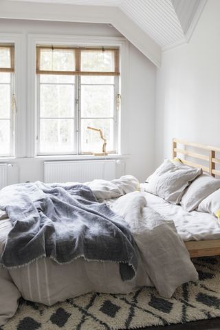 Grey and white layered bedding in a scandi bedroom