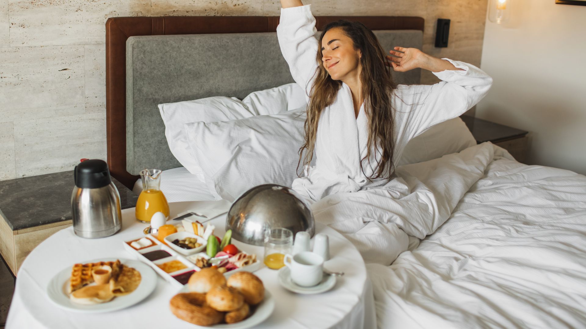 A woman stretches as she wakes up to a hearty breakfast after sleeping through the night. 