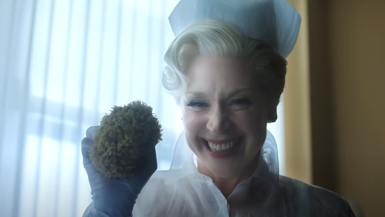 Gwendoline Christie in a nurse costume smiling with a sponge in hand in Wednesday Season 2 Part 2 trailer