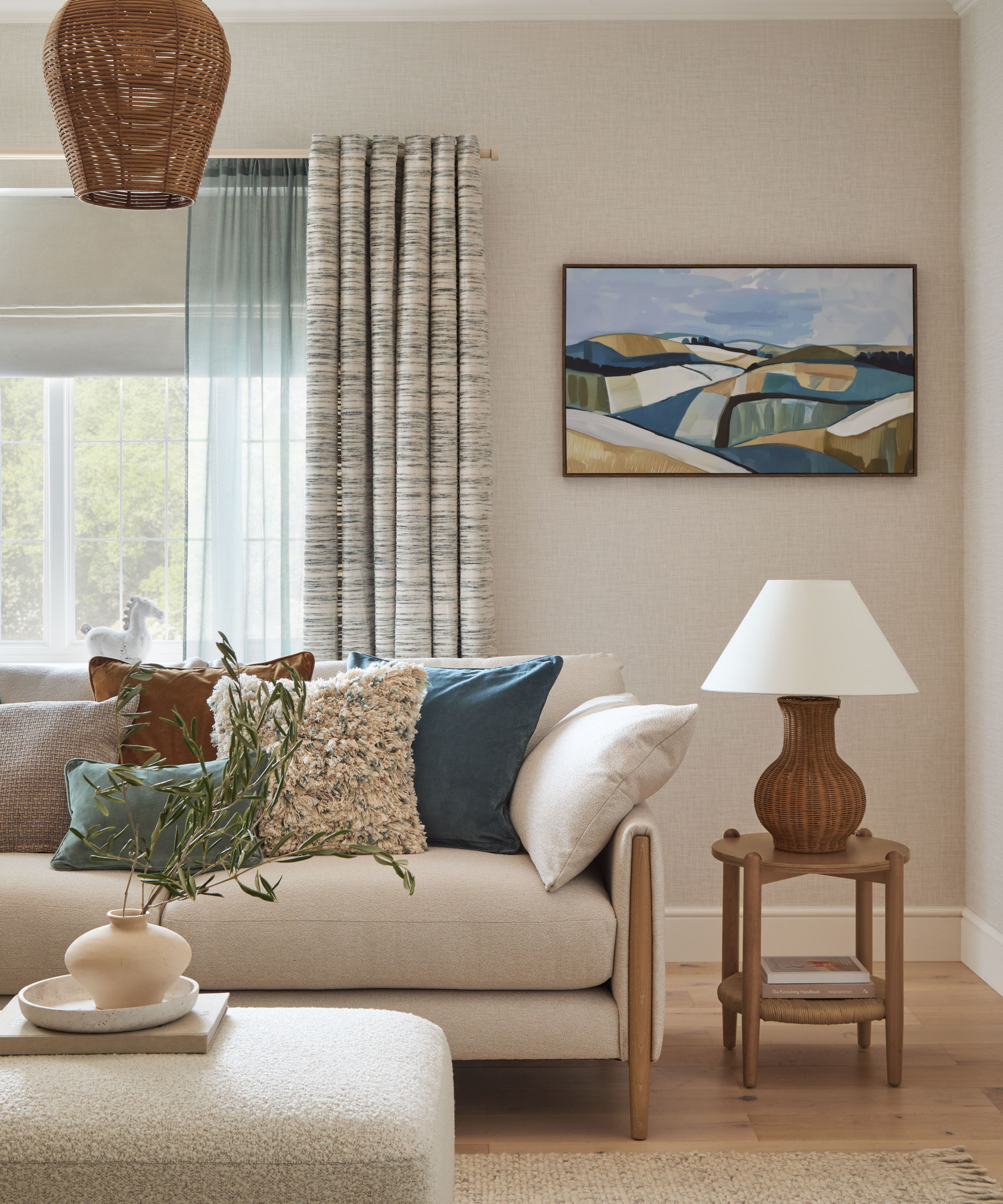 coastal themed living room with large window with three layers of coverings