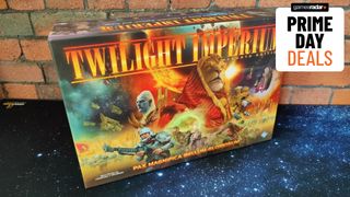 A Twilight Imperium board game box against a brick wall, sat on a starry mat, with a 'Prime Day deals' badge in the top right corner of the frame