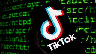 The TikTok logo is seen on a mobile with cyber code displayed on the screen in Brussels, Belgium, on March 21, 2023.