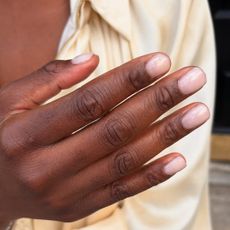 A close up of sheer pink short nails
