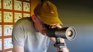 Bird spotting scope on tripod in bird watching hide