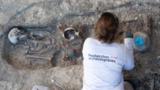 An archaeologist excavates the skeleton of a child in the necropolis.