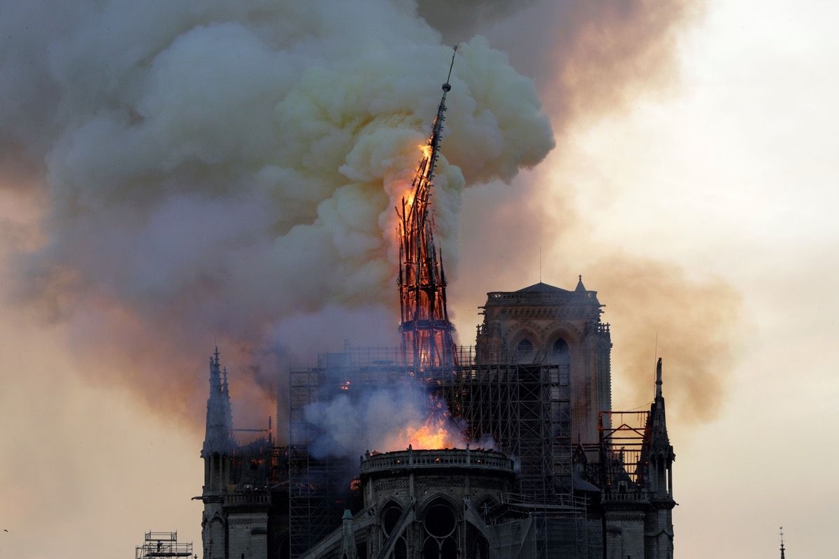 The steeple of the Notre Dame Cathedral collapses as the cathedral is engulfed in flames in Paris on April 15, 2019. 