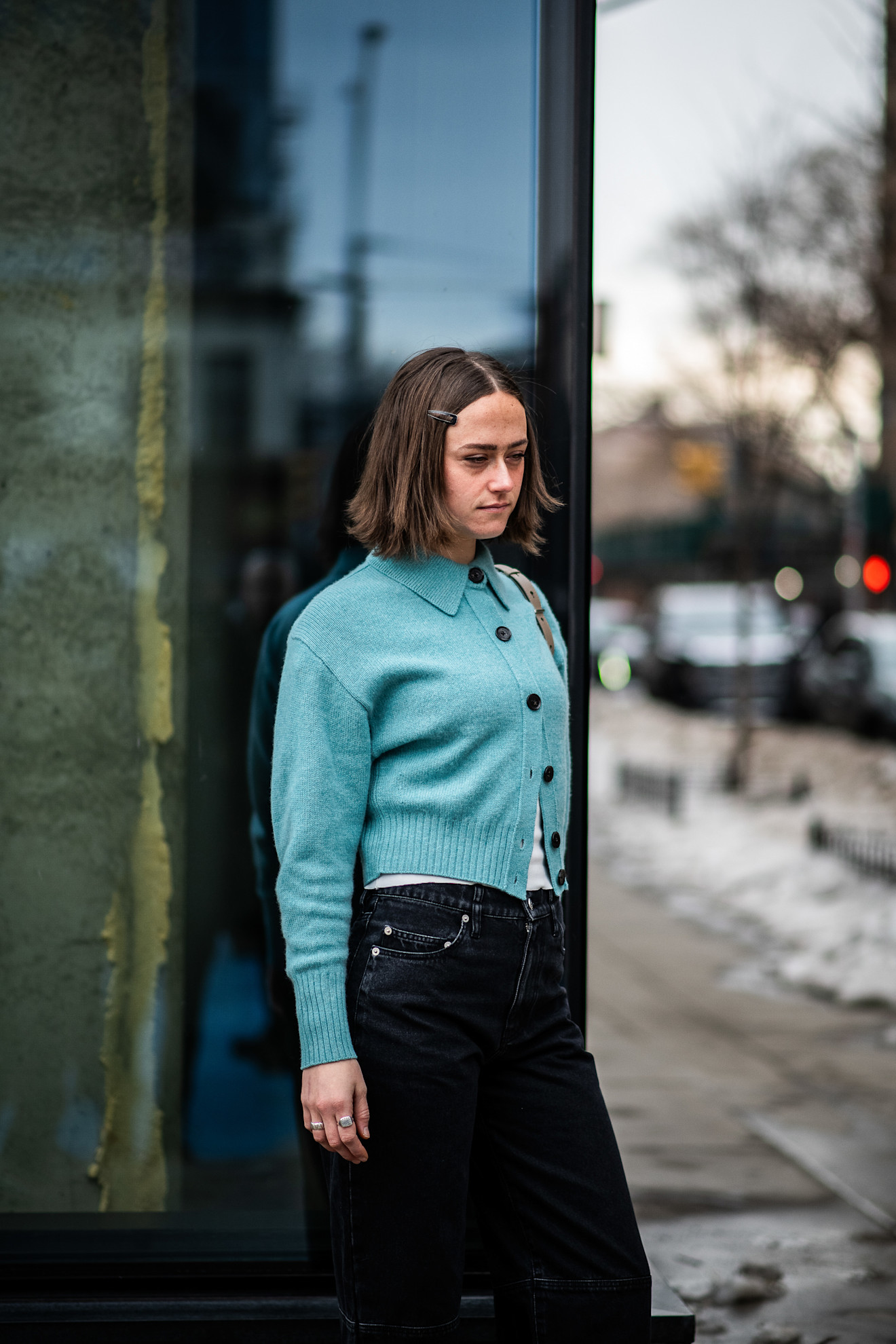 a woman in a blue cardigan with a short brunette bob