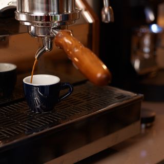 A cup being filled with coffee from a coffee machine