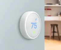 The Nest Thermostat E mounted on a blue wall