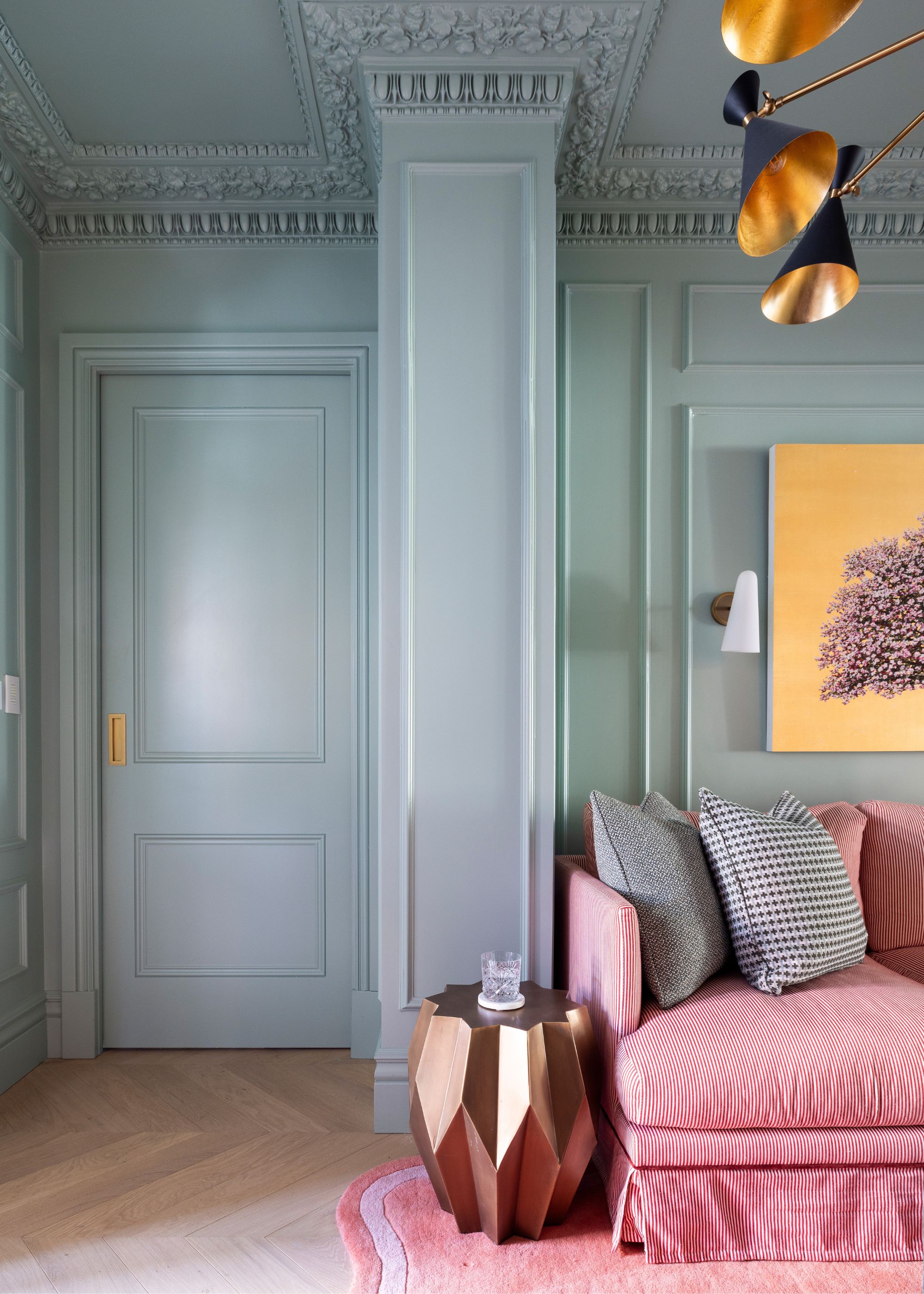 Living room with light blue color-drenched walls and a pink sofa.