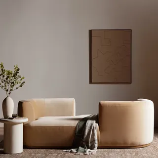 Modern living room with a beige, velvet tete-a-tete sofa that has a gray rustic throw blanket resting over it