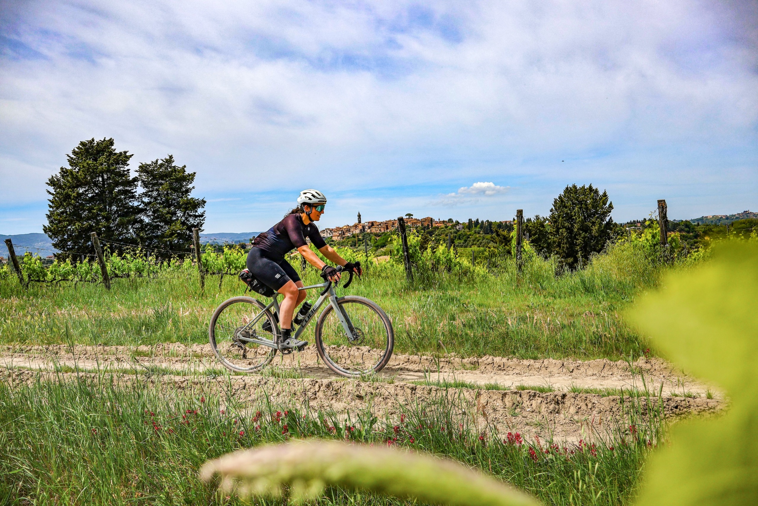 Emma Magnus cycling on a gravel track in Tuscany