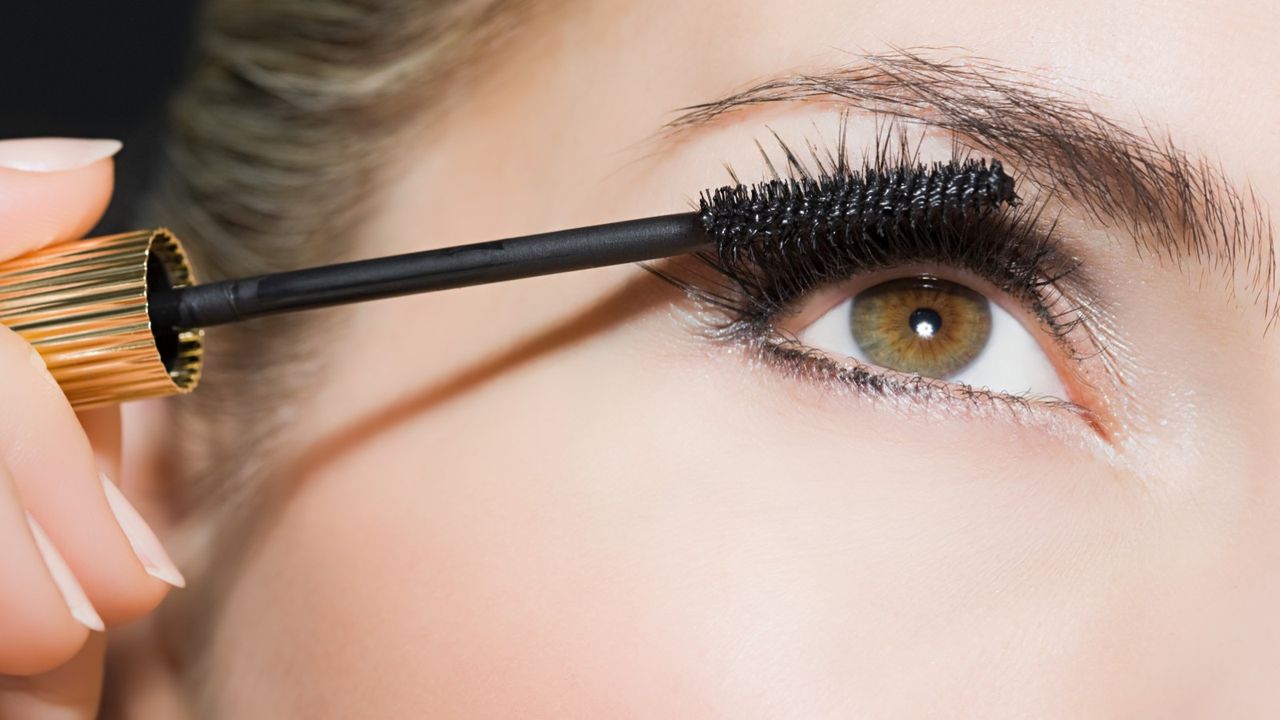 Woman applying mascara - stock photo