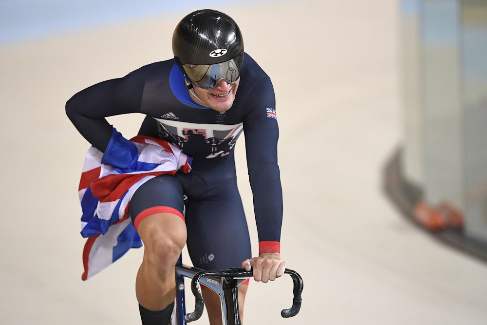 Britain's Callum Skinner holds a flag as he celebrates after winning gold in the men's Team Sprint
