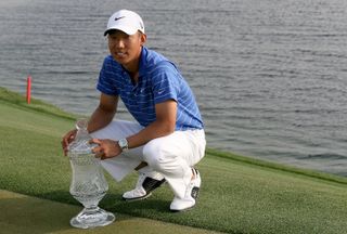 Anthony Kim poses next to the 2010 Houston Open trophy