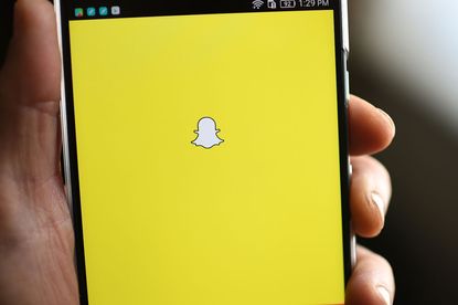 The Snapchat logo appears on a phone screen