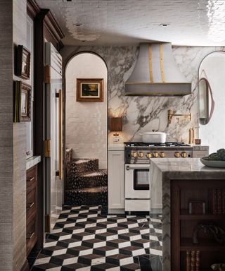 white kitchen with marble countertops and walls, white wall cabinets, white oven, black and white floor tiles