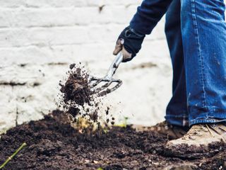 man digging soil with fork
