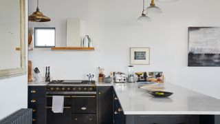 Monochrome kitchen with black cabinets and white stone countertops