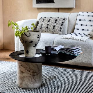 Living room with white boucle sofa, table, rug