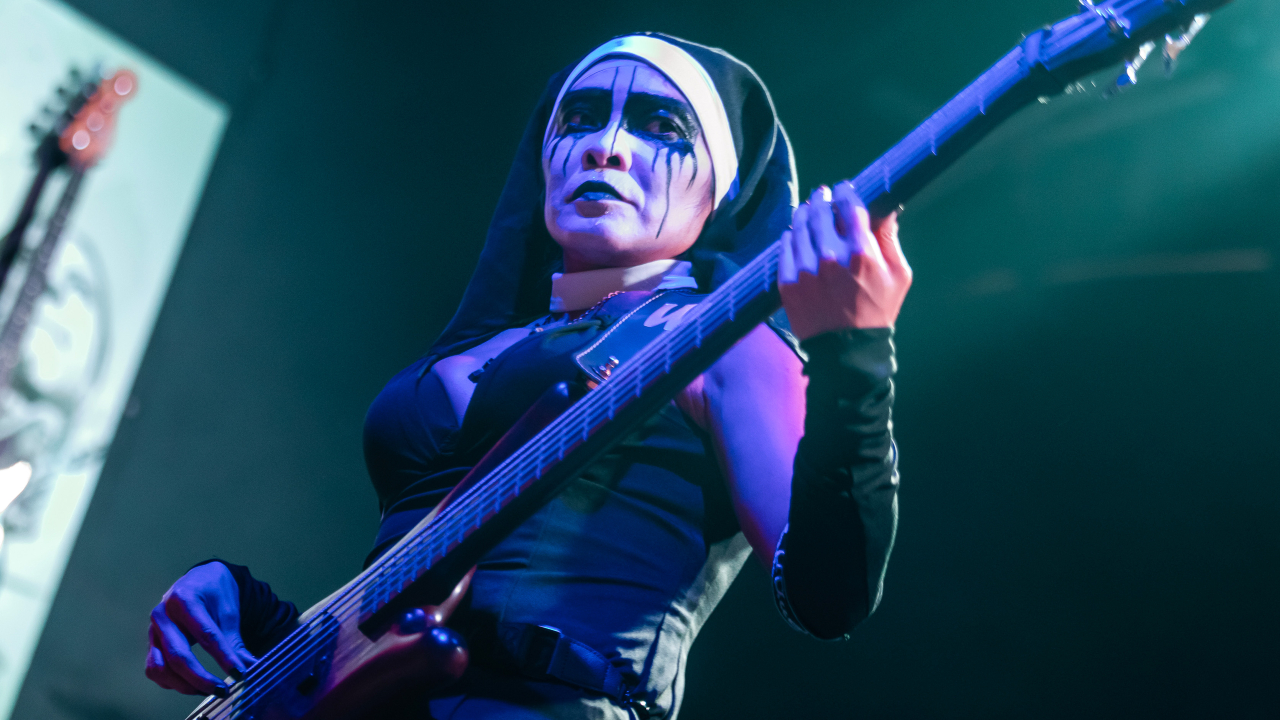 Nixe, bassist of heavy metal band Dogma, performing in a nun outfit and black-and-white face paint in 2025