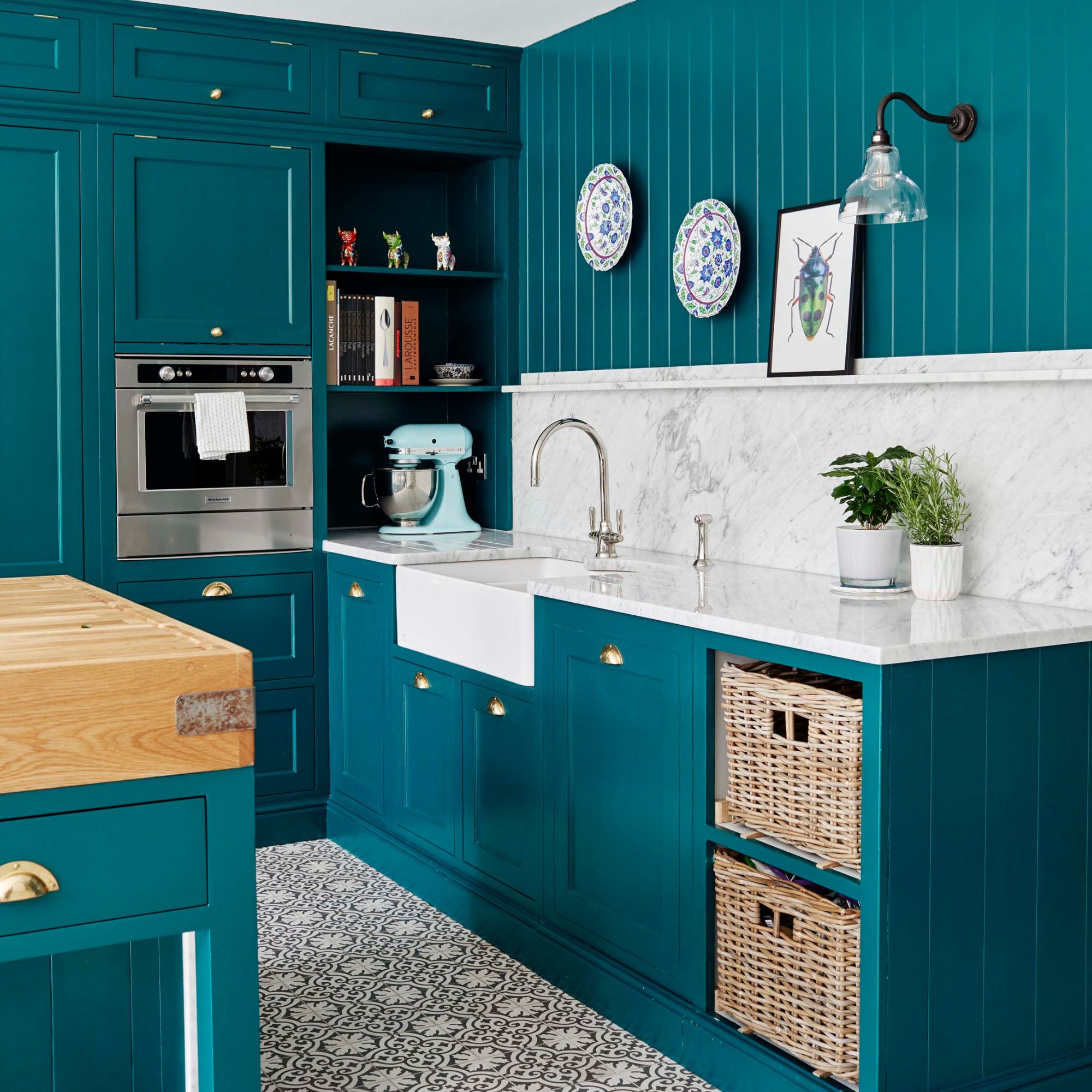 Kitchen with teal painted cabinets and a sink area on the right with a marble backsplash