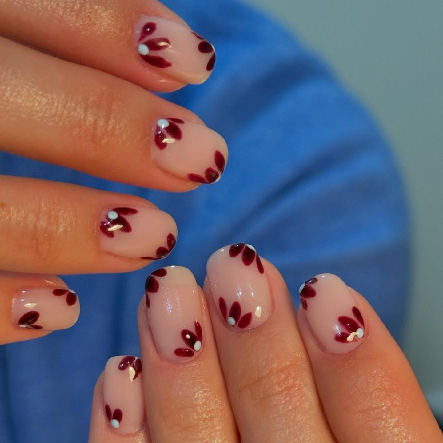 A close-up picture of plum floral nail art