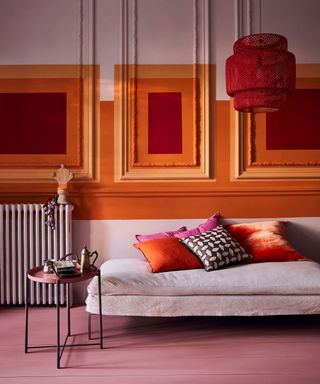 a stylish living room with a chaise lounge, red lampshade and a side table, decorated in Annie Sloan's Chalk Paint in Antoinette Barcelona Orange Emperor's Silk and wall paneling