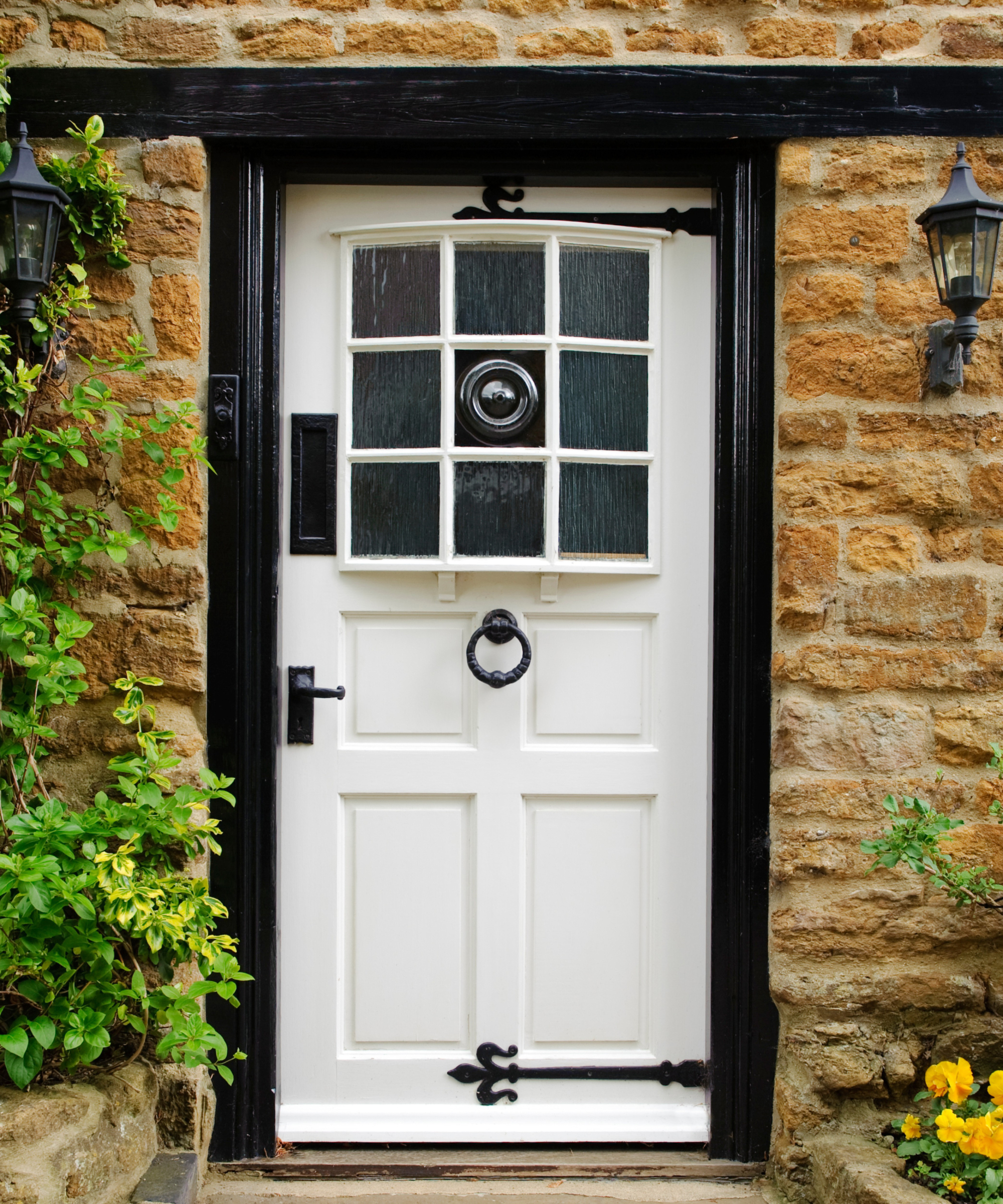traditional white painted wooden front door with bowed glazed panelled top half and black hardware