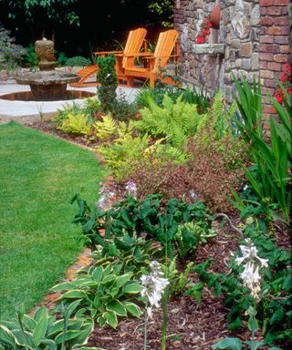 flowerbed covered in wood chips leading to a patio