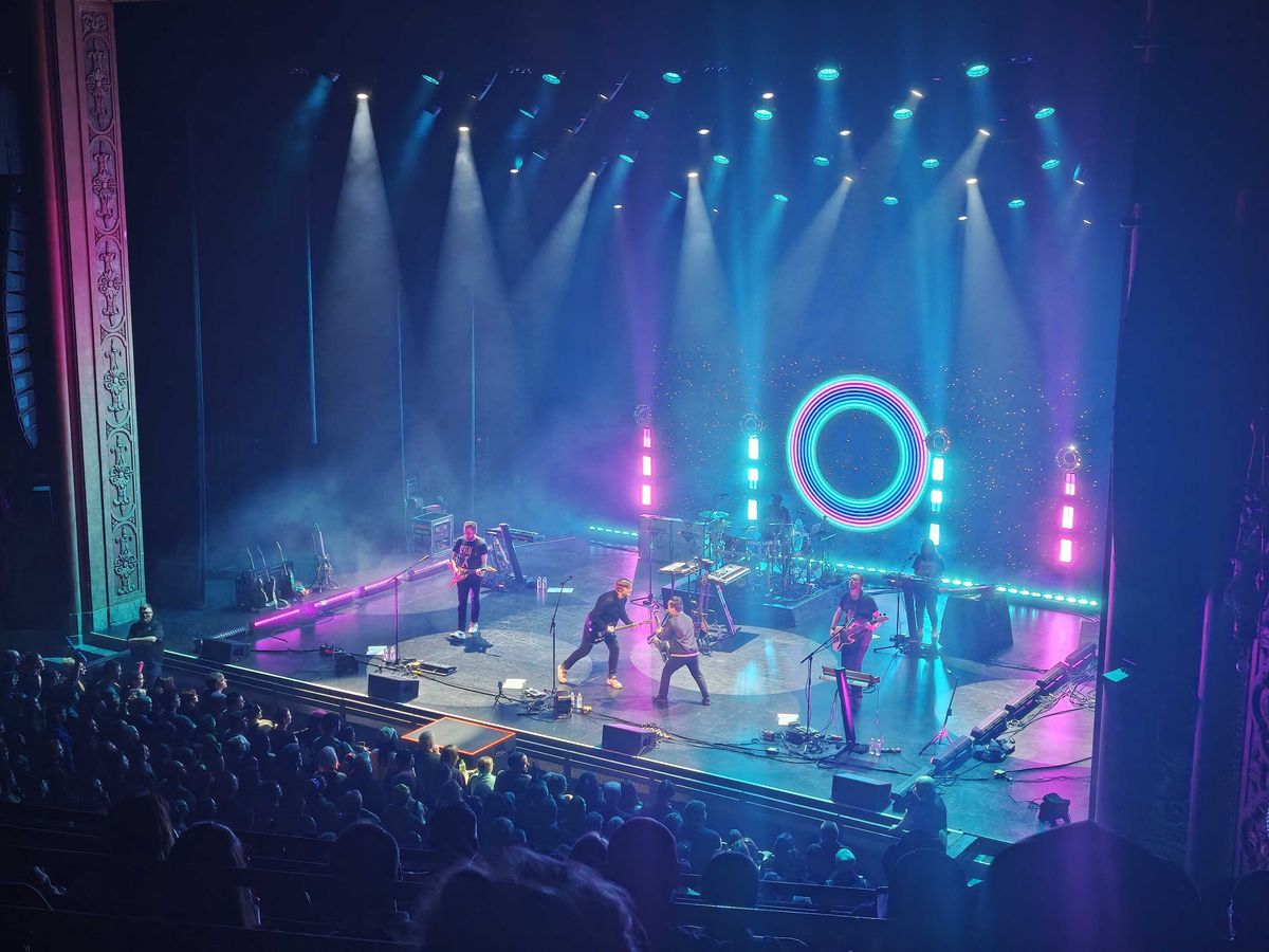 A band playing on a blue and purple-lit stage