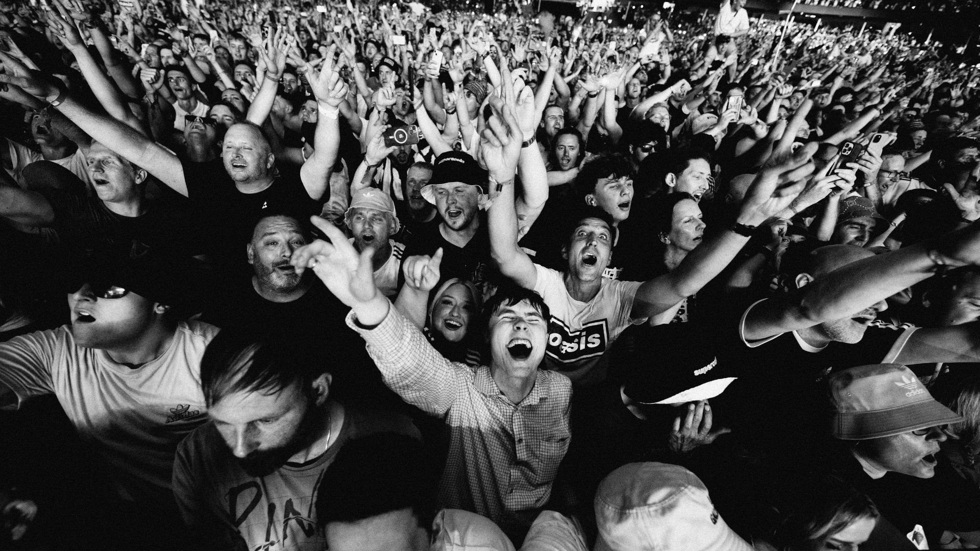 a black and white image of the crowd at an oasis concert during Live 25