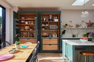 open green cabients in kitchen with appliances and breakfast essentials