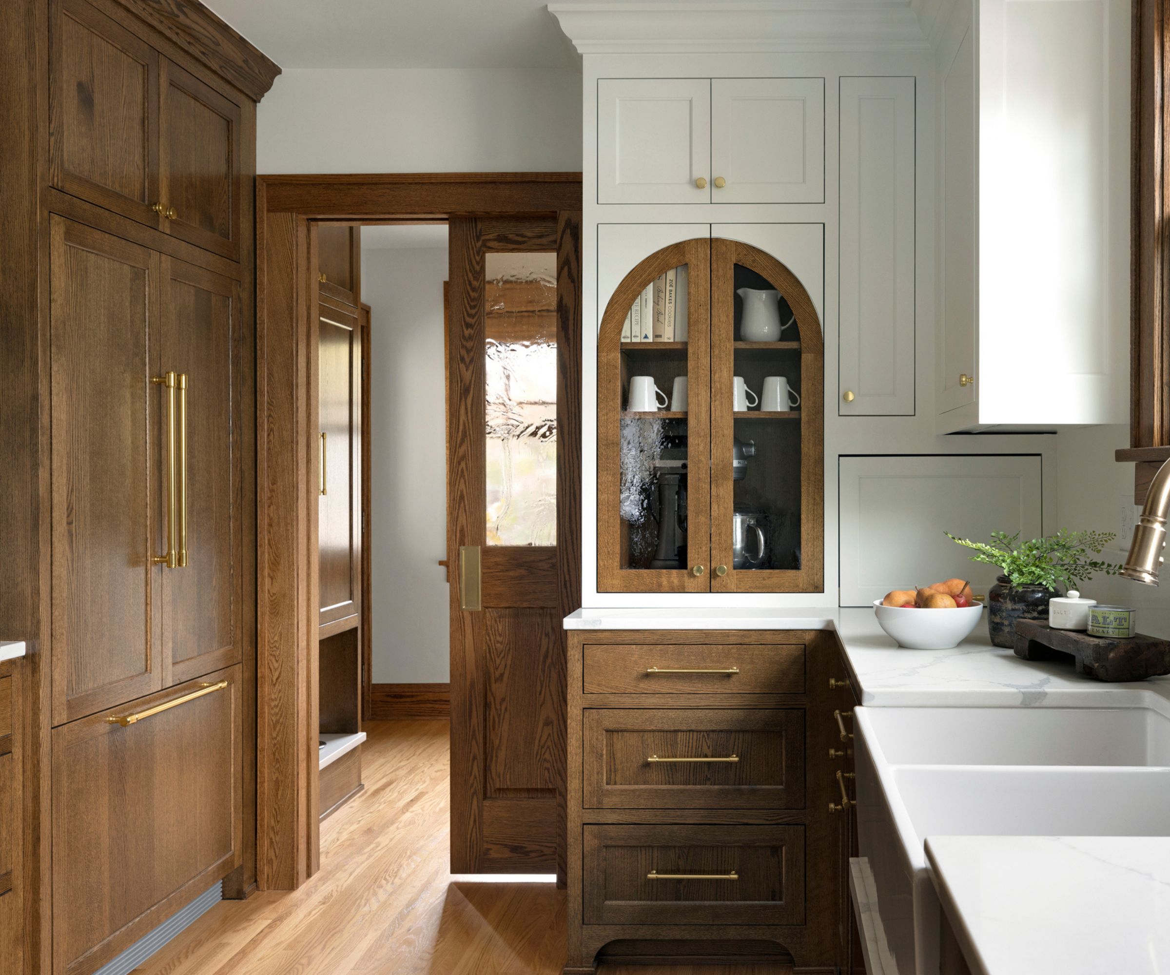 A small kitchen with wooden cabinets and an integrated fridge