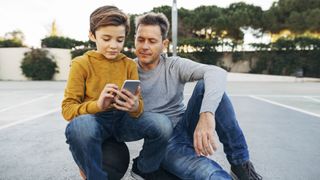 Individual vs Family Cell Phone Plans: image shows father and son looking at cell phone