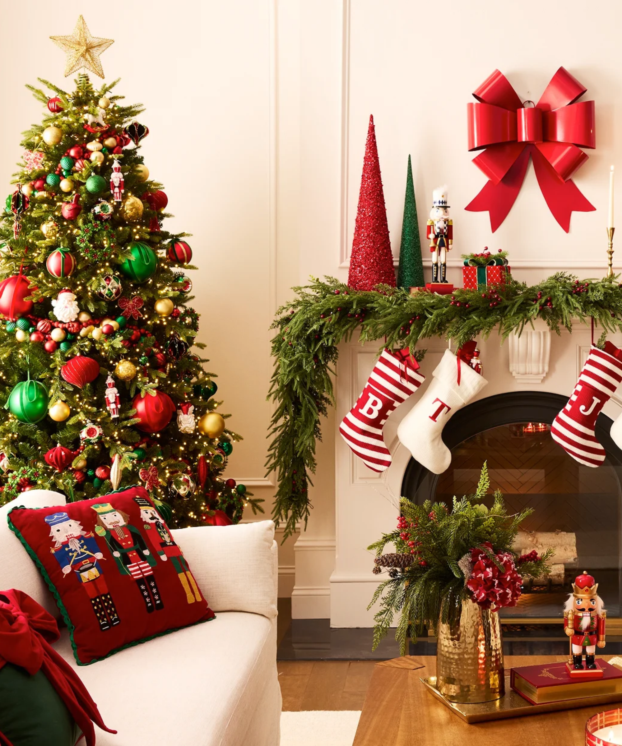 Classically festive living room featuring a characterfully decorated tree of colorful ornaments and an oversized gold star, alongside a mantel dotted with stockings, gift-style wall bow, and garland.