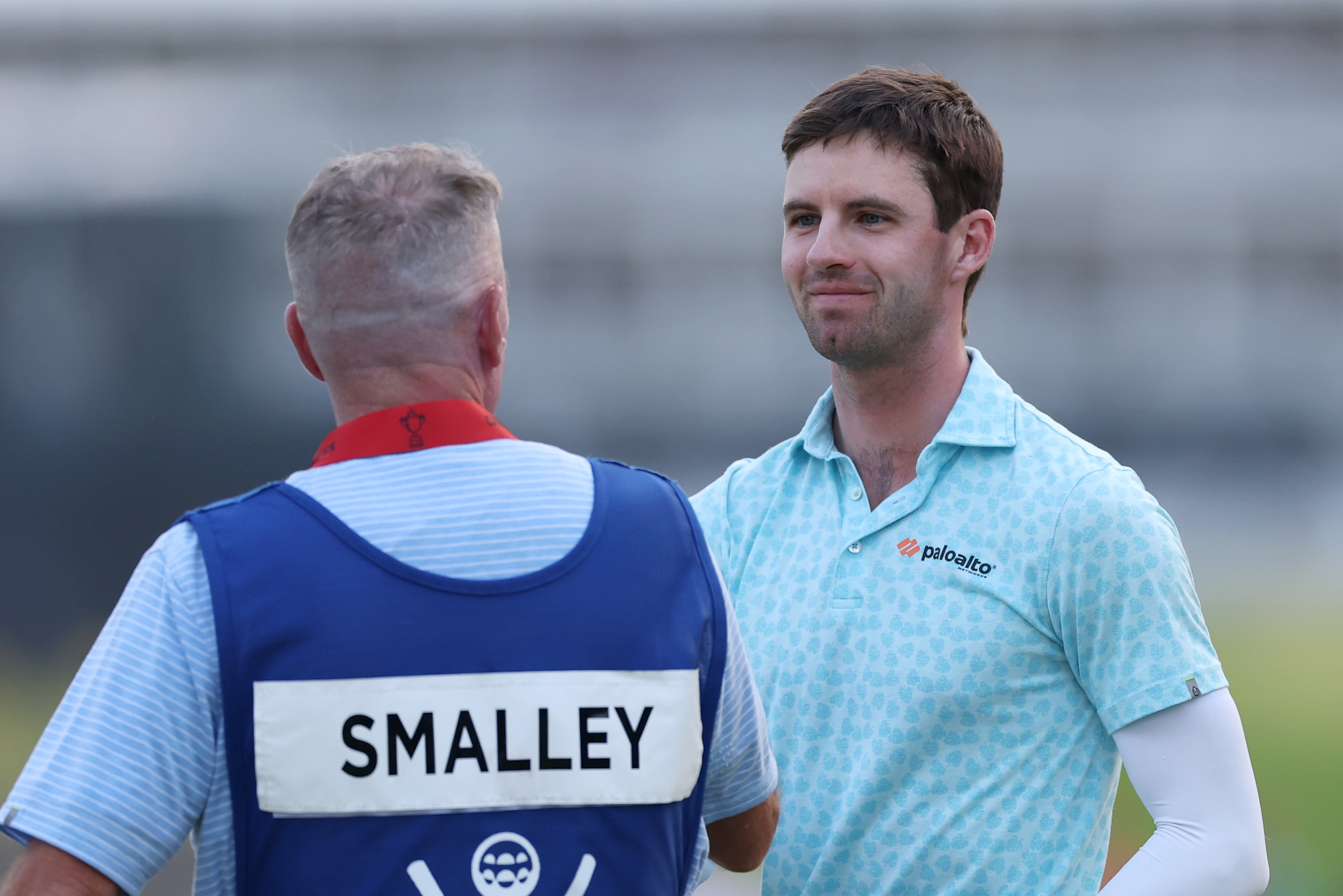 Alex Smalley of the United States shakes hands with his caddie Michael Burns on the 18th hole green during the third round of the PGA Championship at Aronimink Golf Club