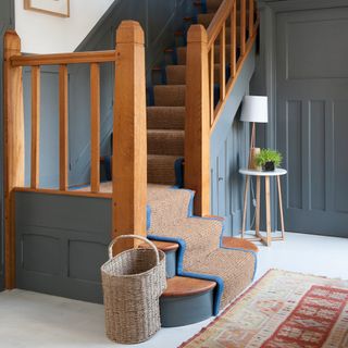 Blue painted stairs with neutral stair runner with a blue trim
