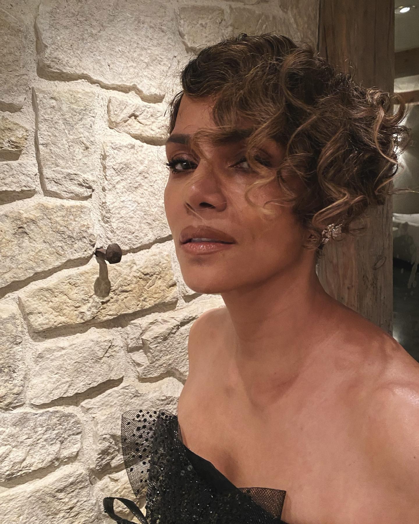 Halle Berry with side-swept curly bangs.