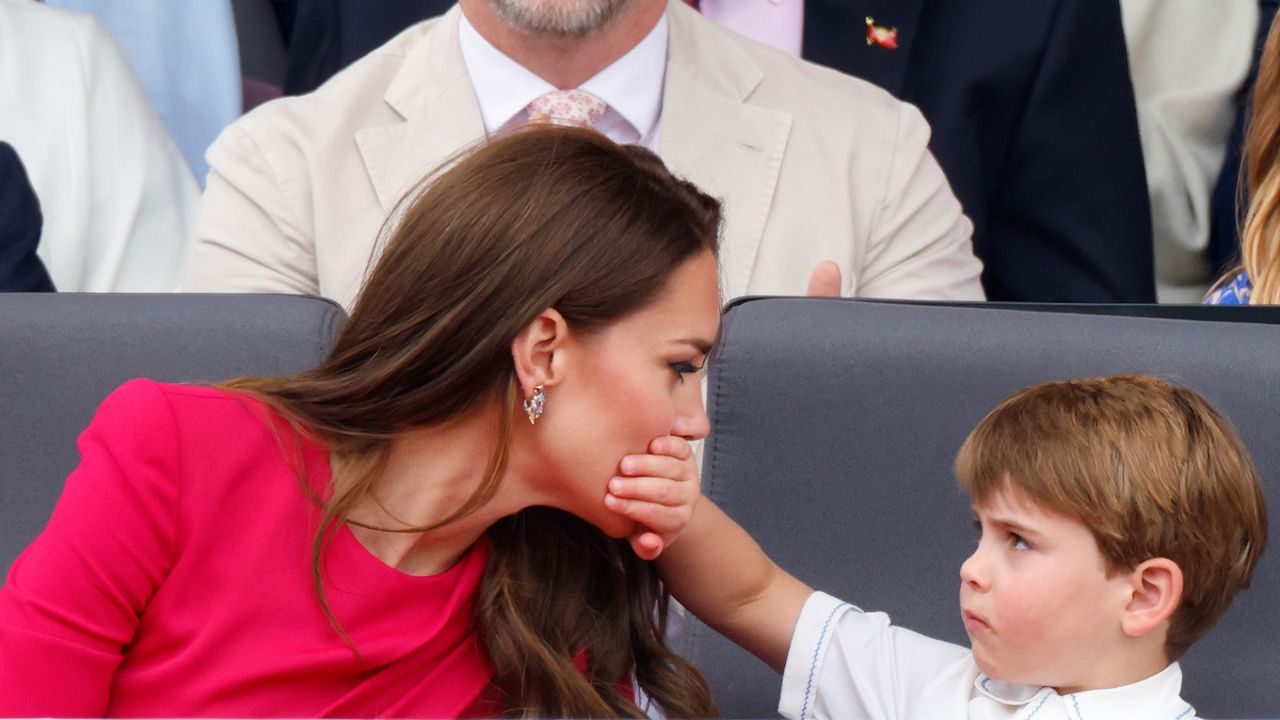 Prince Louis of Cambridge covers his mother Catherine, Duchess of Cambridge&#039;s mouth with his hand as they attend the Platinum Pageant on The Mall on June 5, 2022 in London, England. The Platinum Jubilee of Elizabeth II is being celebrated from June 2 to June 5, 2022, in the UK and Commonwealth to mark the 70th anniversary of the accession of Queen Elizabeth II on 6 February 1952. 