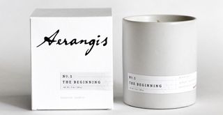 best scented candle on a pale gray background next to white box