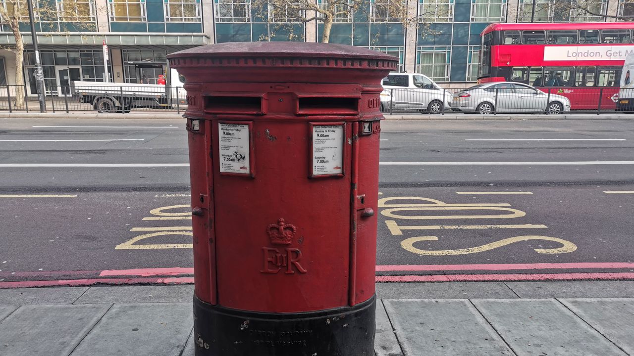 A grimy postbox, with a bright bus in the rear. Image credit: TechRadar